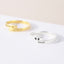 Gold and silver rings with paw prints and names on a white background