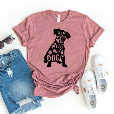 Pink t-shirt with dog graphic and text, paired with denim shorts and white sneakers on a white background