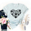 Light blue t-shirt with black paw print heart design, jeans, sneakers, and a flower on a white background