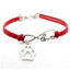 Red bracelet with silver infinity charm and paw print on a white background