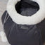 Gray pet carrier with white interior on a light wooden floor