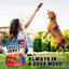 Woman and dog playing with a bag of Bixbi Chicken Jerky treats in a garden setting.