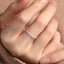 Silver ring with engraved text on a person's finger against a neutral background
