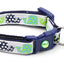 Dog collar with green paw print pattern and blue bell on a white background